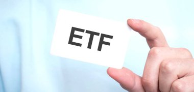 Mavi tişörtlü bir adam elinde metin ve iş konseptiyle bir kart tutuyor.