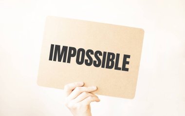 Kapalı kapılar ardında el ele tutuşan işadamı, boş kağıt kağıtları gösteriyor. Boş beyaz tahta boşluğunu, mesaj kuralı ya da protesto sözcüğü için taklit ediyor. Olanaksız Metin