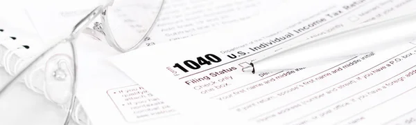 US tax form 1040 with a silver pen and glasses