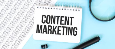 Mali belgelerde beyaz not defteri ve büyüteç. Metin İçeriği Pazarlama. İş konsepti