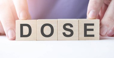 İş adamı, masa arkasında DOSE iş sözcüğünün yazılı olduğu tahta küp bloğu tutuyor. Görev, Vizyon ve temel değerler kavramı