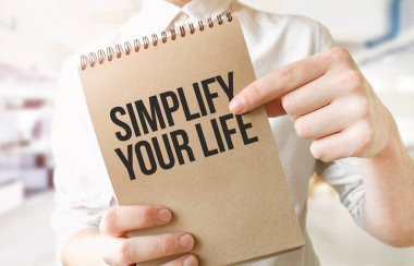 SIMPLIFY hayatınızı kahverengi kağıt not defteri üzerinde metin işadamı ellerinde. İş konsepti