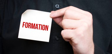 İş adamı elinde metin formasyonu, iş konsepti içeren bir kart tutuyor