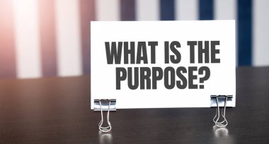 Güneş ışığında karanlık masanın üstündeki kağıttaki PURPOSE işareti nedir? Mavi ve beyaz arkaplan