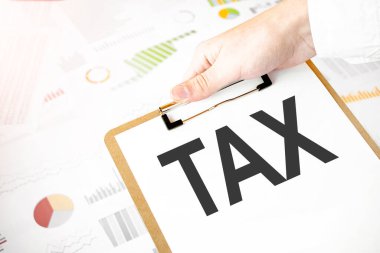 Beyaz kağıt tabağa konan yazı vergisi işadamlarının elinde ve finansal diyagramı var. İş konsepti