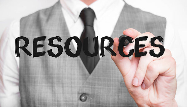 Бизнесмен пишет слово RESOURCES с маркером, бизнес-концепция