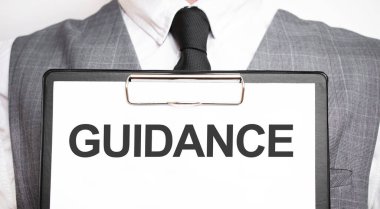 Elinde mesaj rehberi olan bir kağıt parçası tutan bir iş adamı.