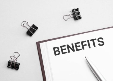 paper note with text BENEFITS, pen and office tools, white background. business concept