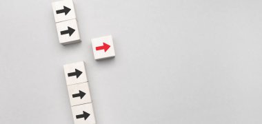 Liderlik kavramı, ahşap blok ve mavi arkaplanda kırmızı ok simgesi.