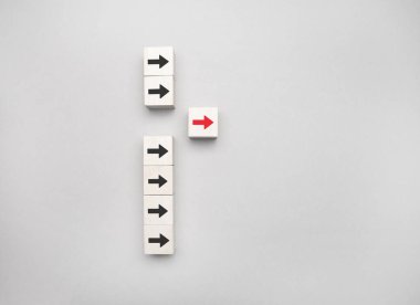 Liderlik kavramı, ahşap blok ve mavi arkaplanda kırmızı ok simgesi.