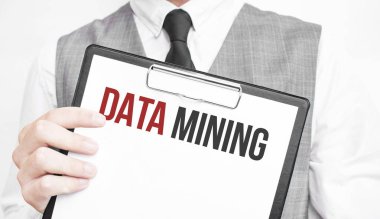 Gri arkaplanlı bir iş adamının elindeki bir defterde DATA Madencilik yazılıydı.