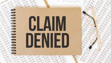 CLAIM DENIED yazı ile renk not defteri. Gözlüklü ve metin belgeli not defteri. İş konsepti