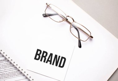 İş konsepti. Gri arkaplandaki notlar ve gözlükler için beyaz kâğıtlı not defteri