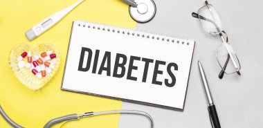 Not defterine steteskop, gözlük, kalem, termometre, kırmızı haplar ve sarı arka planda kalemle mesaj at. Tıbbi konsept.