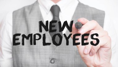 İşadamı keçeli ve ticari konseptli yeni EMPLOYEES kelimesini yazıyor