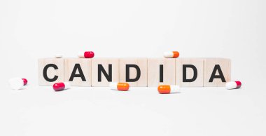 Tahta küplerin üzerindeki sözcük, yansıtıcı beyaz bir yüzey üzerinde duruyor. Tıp konsepti