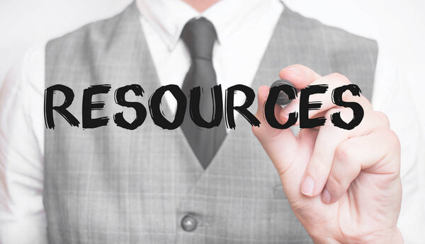 Бизнесмен пишет слово RESOURCES с маркером, бизнес-концепция