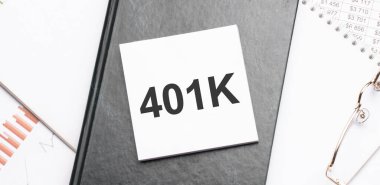 Haritalar ve numaralar üzerinde 401 K yazılı not defteri. İş konsepti.