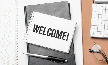 Not defterine ve kahverengi arka plandaki çeşitli iş belgelerine hoş geldiniz. Kahverengi gözlükler ve not defteriyle büyüteç.