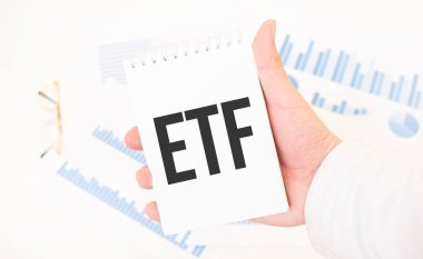 İş adamı elinde iş saatleri ve iş konseptiyle beyaz bir not defteri tutuyor.