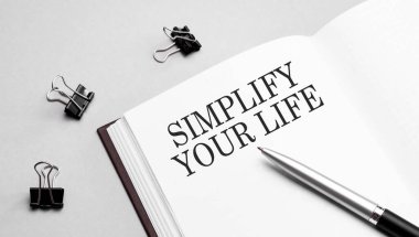 Finans ve ekonomi kavramı. Beyaz arkaplanda büyüteç, metnin içinde SIMPLIFY YAŞINDA yazılıdır