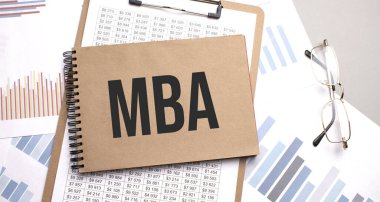 Grafikler ve numaralar üzerinde MBA metni olan not defteri. İş konsepti.