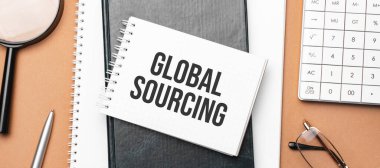 Not defterindeki küresel kaynak ve kahverengi arka plandaki çeşitli iş kağıtları. Kahverengi gözlükler ve not defteriyle büyüteç.