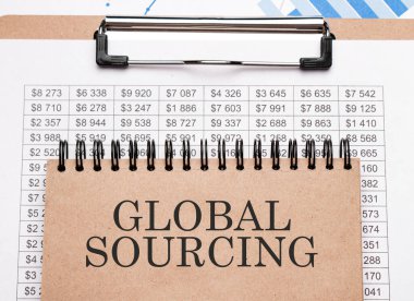 Grafikler ve numaralar üzerinde küresel metin kaynaklı not defteri. İş konsepti.