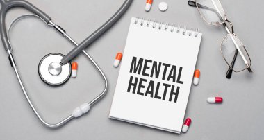 Defterde steteskop, hap ve bardakların yanında ruh sağlığı mesajı var..