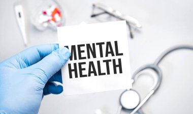 Doktorun mavi eldivenli elleri akıl sağlığını gösteriyor. Beyaz arka planda eldivenli bir el. Tıbbi konsept. İlaç.