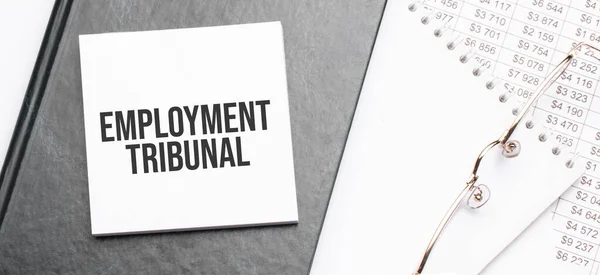 Text employment tribunal on notepad with office tools, pen on financial report . Business and financial conzept. calculator and the working paper with a diagram.