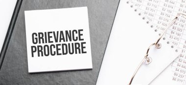 Ofis araçlarıyla not defterine şikayet metni yaz, mali rapora kalem at. İş ve mali konzept. Hesap makinesi ve diyagramı olan çalışma kağıdı.