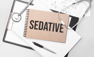 Yazılı yatıştırıcı. Masanın üstünde steteskop, kalem ve tıbbi belgeler var. Sağlık hizmeti kavramı.