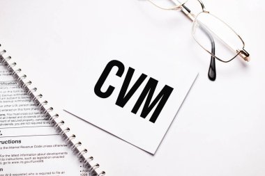 İş konsepti. Gri arkaplanda notlar ve gözlükler için beyaz kağıttan metin CVM sayfası olan defter