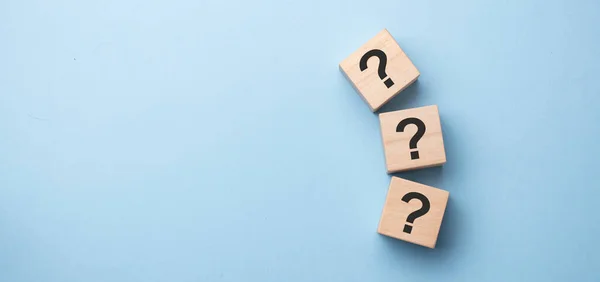 Tahta kübün blok şekli ve tahta masanın üzerinde işaret işareti işareti var..