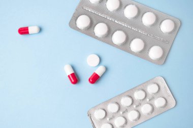 Mavi arkaplan üzerinde antibiyotikler çift renk kapsülleri.