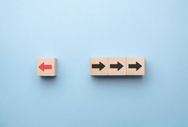 Red arrow print screen on wooden block change direction from right to left which differ from black arrows , Business and technology disruption concept.
