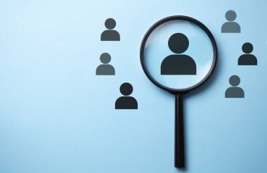 İnsan kaynakları yönetimi ve adam toplama konsepti. Büyüteç insan simgesini arıyor.