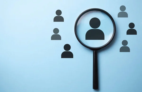 İnsan kaynakları yönetimi ve adam toplama konsepti. Büyüteç insan simgesini arıyor.