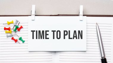 text TIME TO PLAN on stickers on the diary with office tools