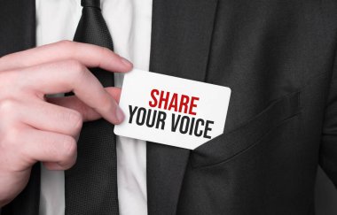 Businessman holding a card with text SHARE YOUR VOICE