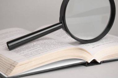 Büyüteç, arama ve okuma konsepti için açılmış eski bir kitap