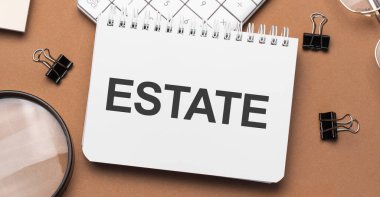 Kalem, gözlük ve hesap makinesiyle dizüstü bilgisayarda arsa