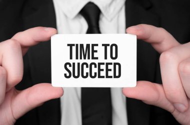 İş adamı elinde başarılı olmak için metin zamanı olan bir kart tutuyor.