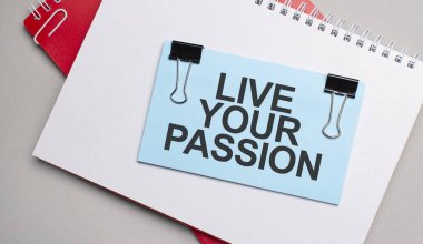 Metni olan mavi renkli çubuk beyaz ve kırmızı not defterinde yaşa.