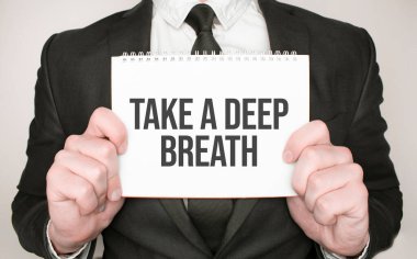 İş adamı elinde not defteri tutuyor. Derin bir nefes al.