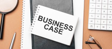 Not defterindeki iş dosyası ve kahverengi arka plandaki çeşitli iş evrakları. Kahverengi gözlükler ve not defteriyle büyüteç.