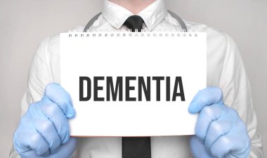 Tıbbi konsept. Doktor beyaz kağıt not defterine DEMENTIA kelimesini yazıyor.