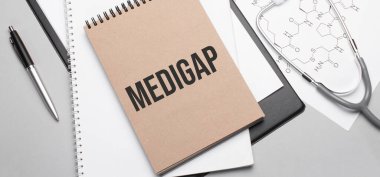 Masaya steteskop, kalem ve tıbbi dokümanlarla tıbbi malzeme girişi. Sağlık hizmeti kavramı.