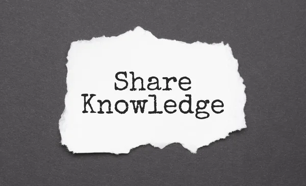 SHARE KNOWLEDGE sign on the torn paper on the black background